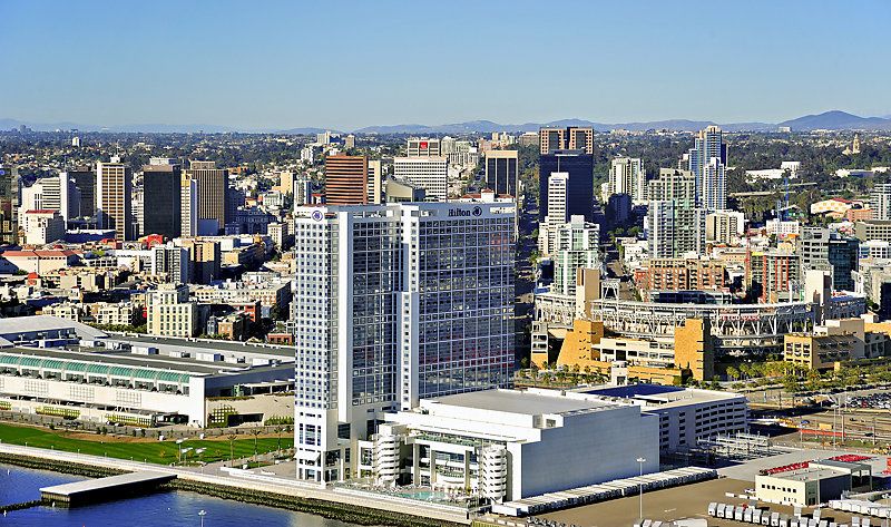 Hilton waterfront hotel pictured with city skyline in the background.