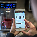 Laval, Canada - March 24, 2016: Human Hand Using the Saeco application on a Apple Iphone6 Plus. The app is being used to control the bluetooth coffee machine. Saeco, is an Italian manufacturer espresso machines.  