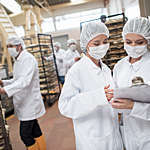 Women working at a food factory and looking at checklist on a clipboard
