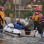 Malton, United Kingdom - November 27, 2012: Young family being rescued by the fire service after the River Derwent burst it's banks in the village of Old Malton in North Yorkshire in northeast England. 