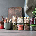 Beans, seeds and cereals in glass jars on a wooden table. Healthy food.