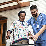Caregiver helping senior woman to walk.