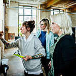 Casual businesswomen having brainstorming and sticking notes on a wall